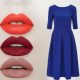 Woman in a royal blue dress applying bold red lipstick in a mirror, showcasing a glamorous makeup look